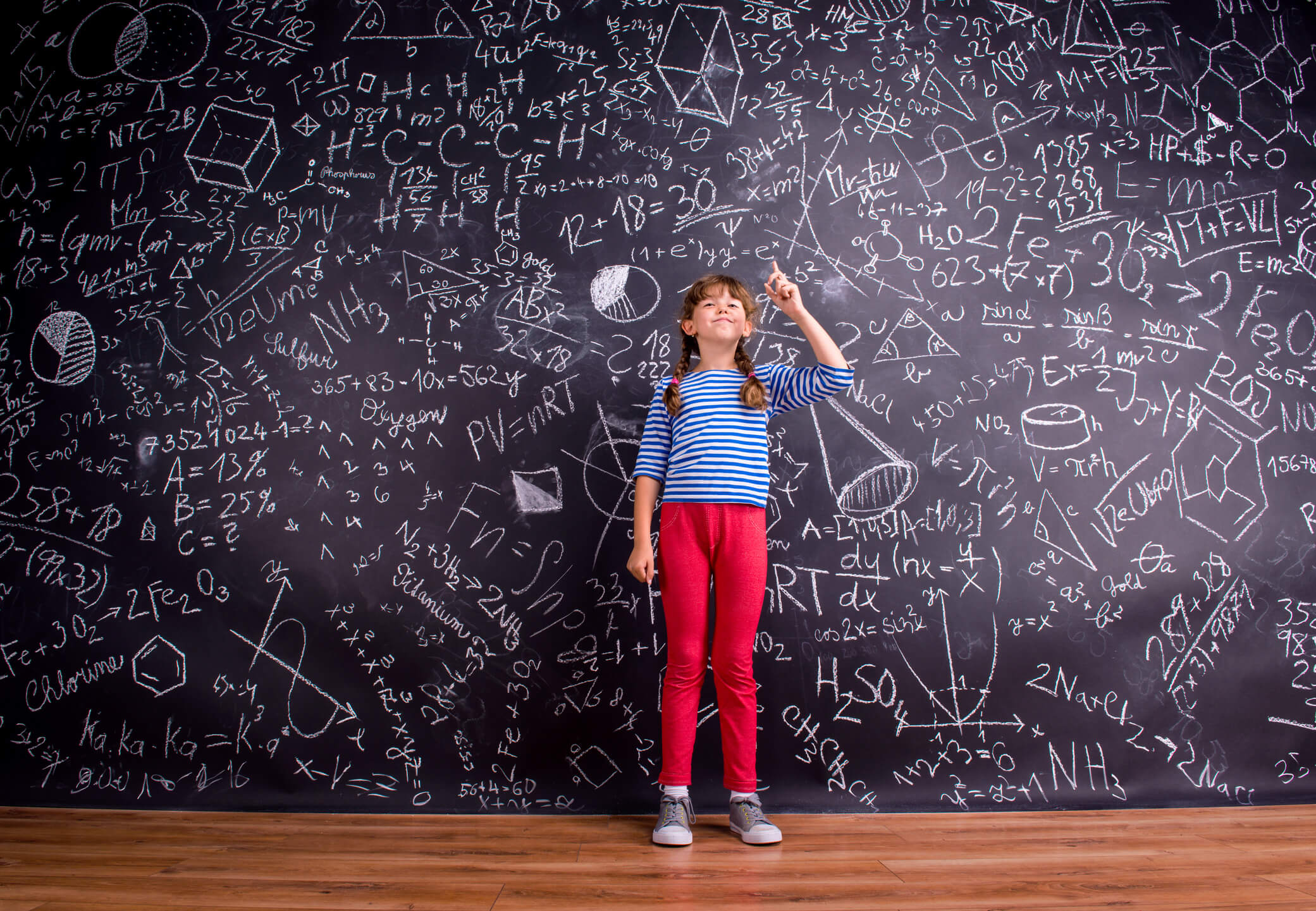 Girl with two braids, big blackboard with mathematical symbols