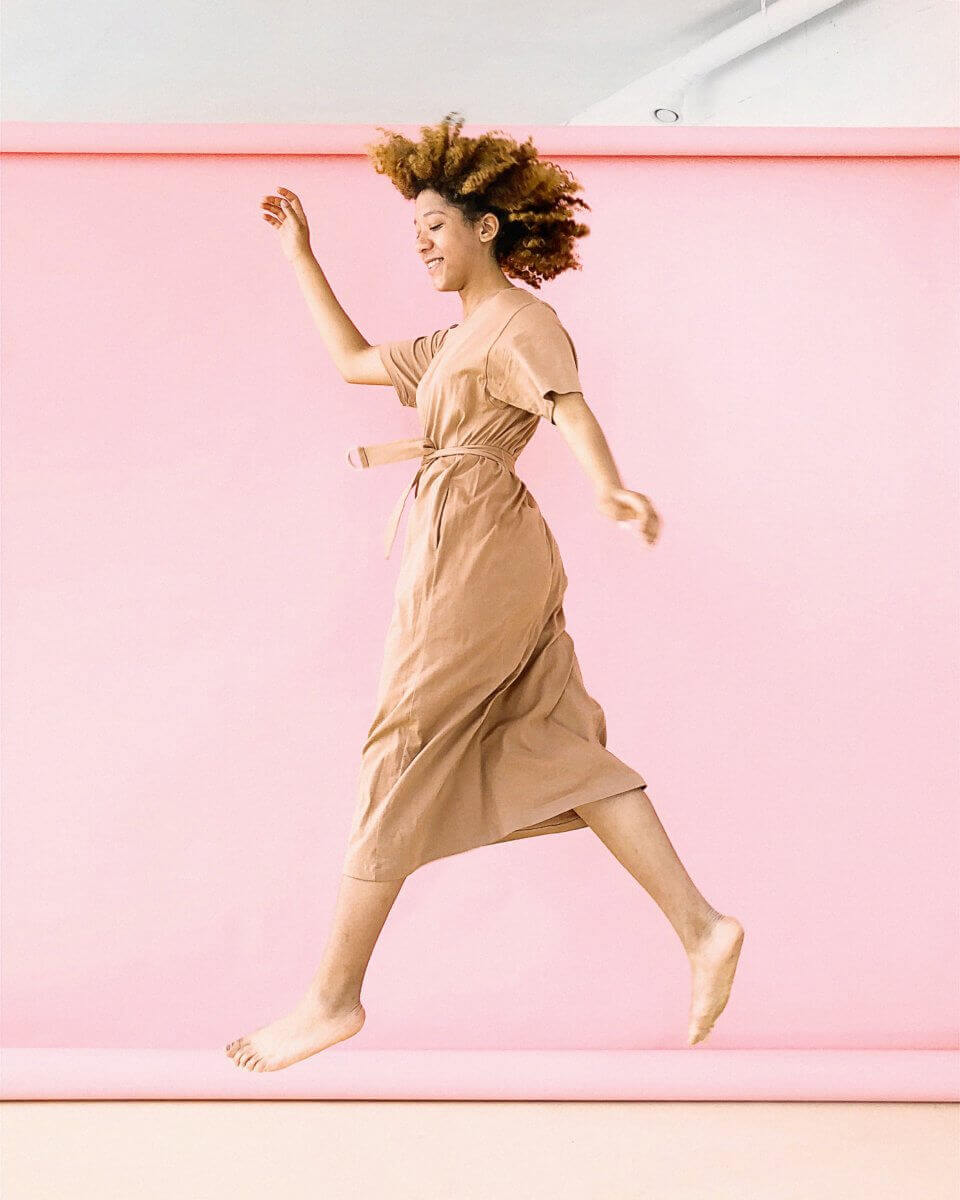 woman-wearing-brown-dress-jump-near-pink-wall-1179141-960×1200