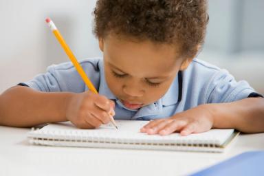 African boy drawing on notebook